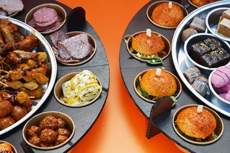 2 borrelschalen met hapjes, desserts en burgers